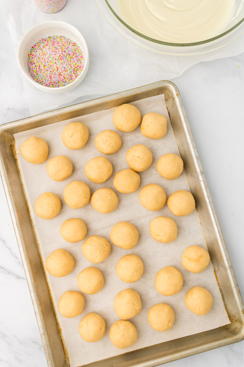 Lemon oreo balls on a baking sheet.