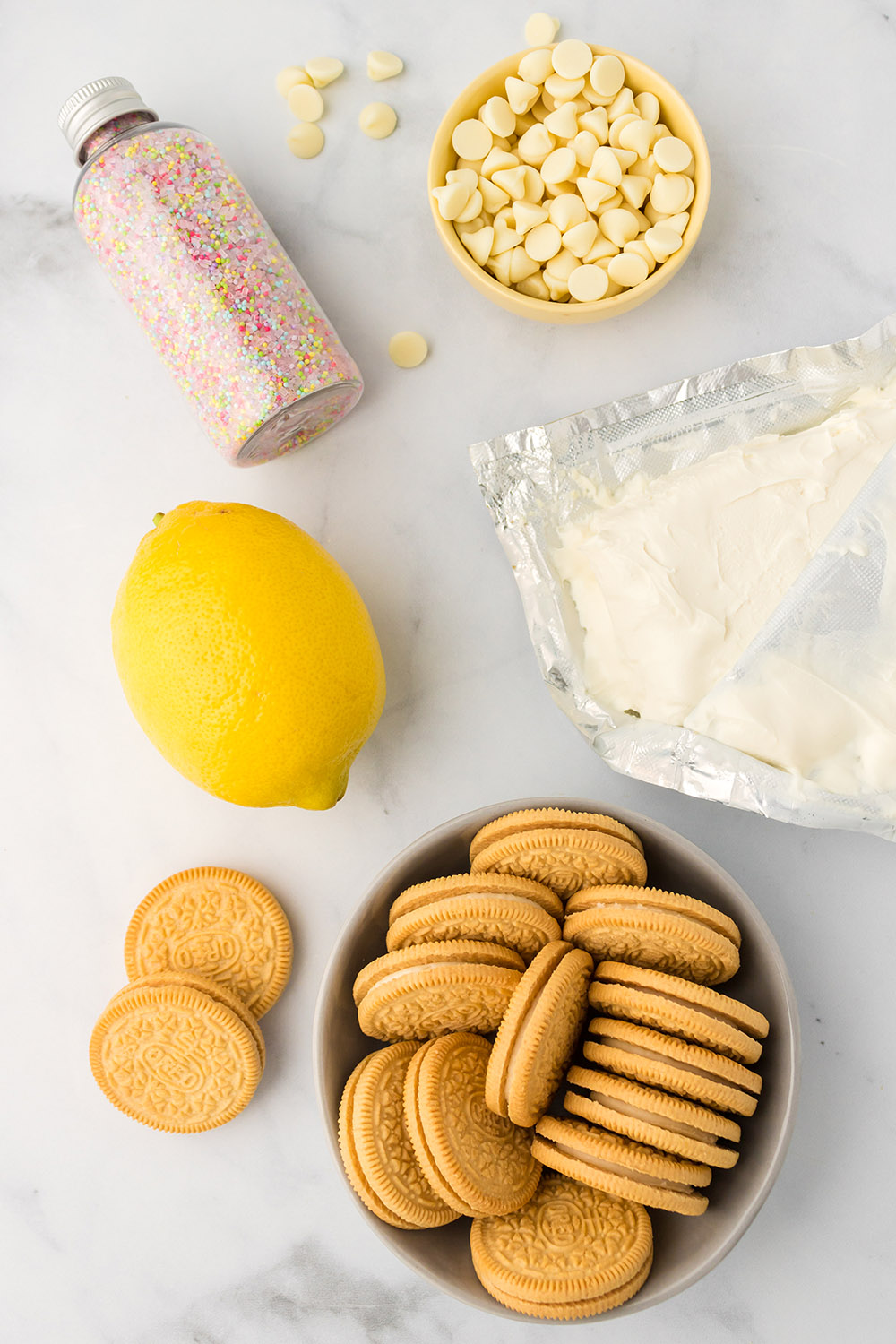 Cookies, lemon, cream cheese, and other ingredients for oreo balls.