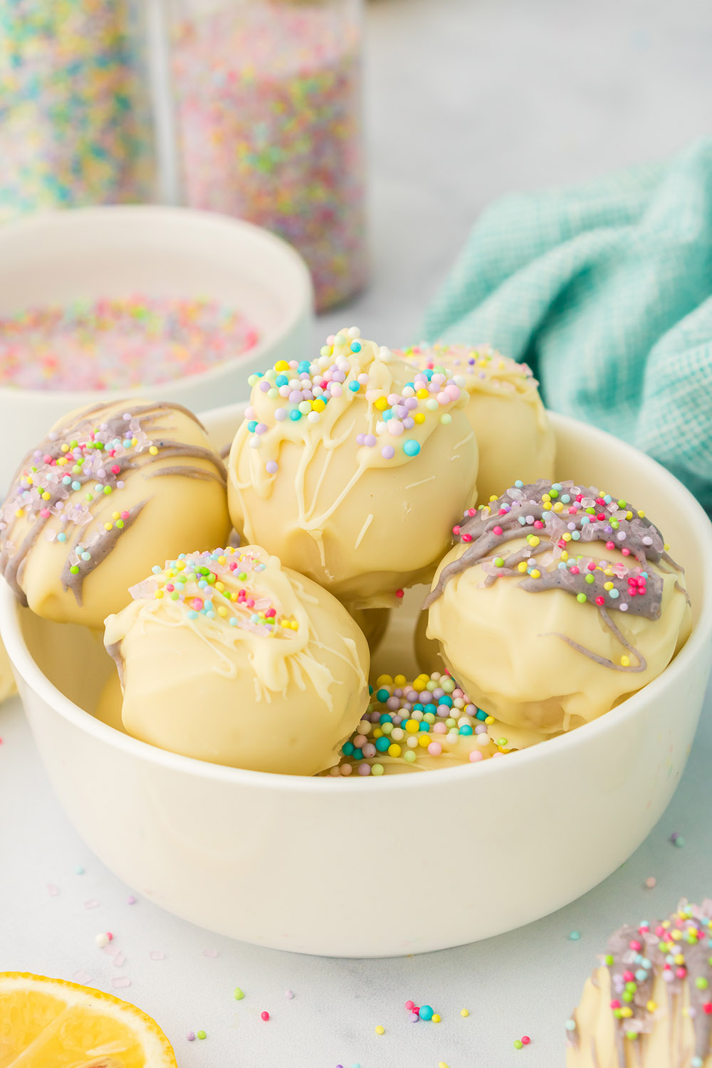 Lemon truffles in a bowl topped with sprinkles.