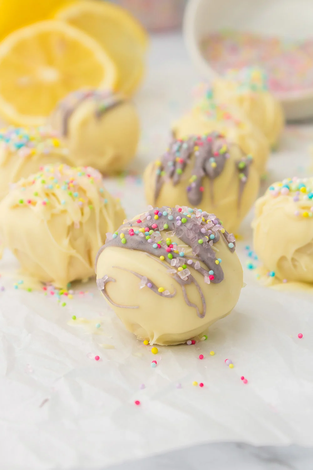 Lemon truffles with purple and yellow topping and sprinkles.