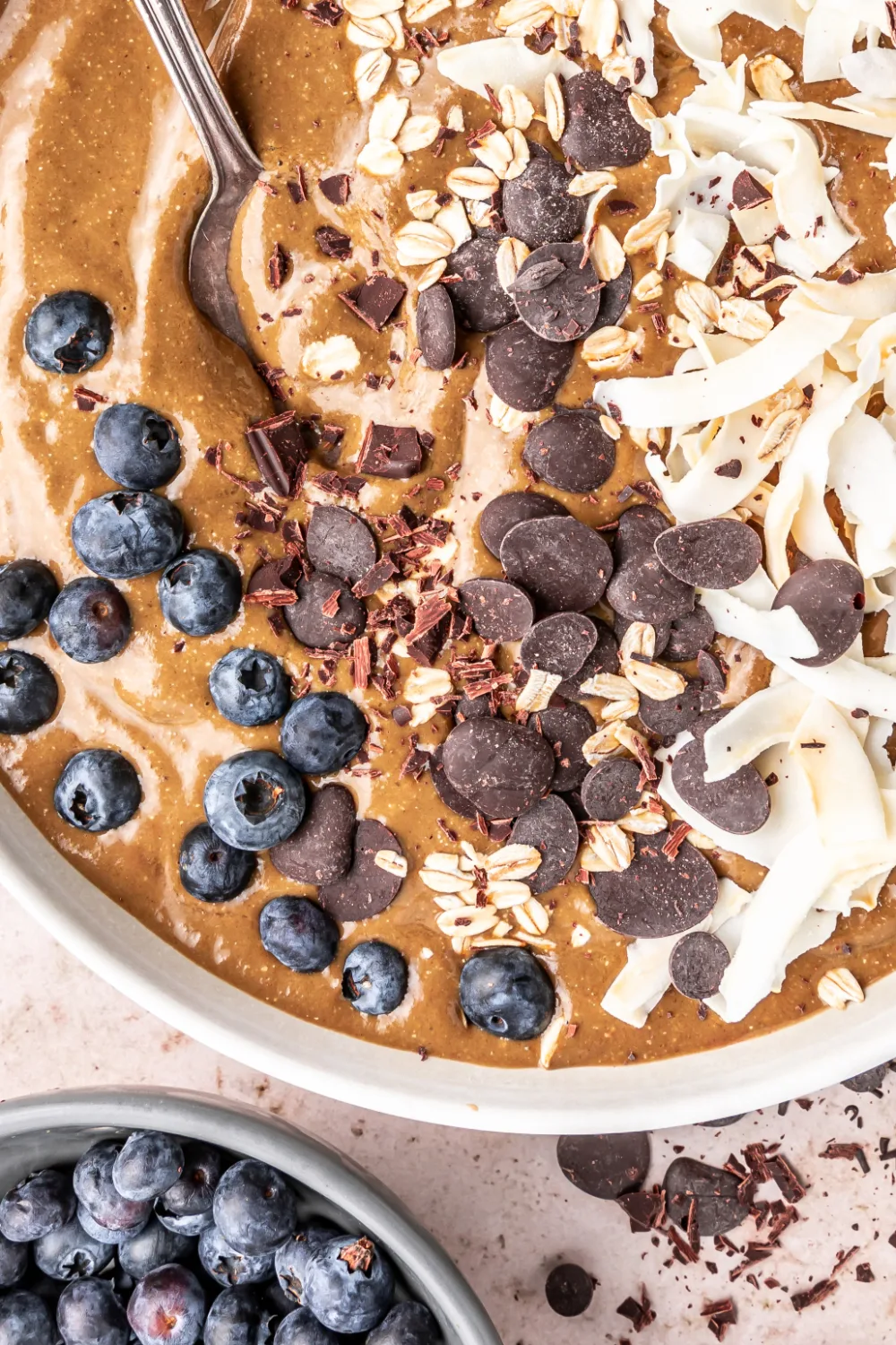 Closeup of a mocha smoothie bowl with blueberries, chocolate chips, and shredded coconut. 