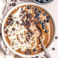 Peppermint mocha smoothie bowl next to a bowl of blueberries.