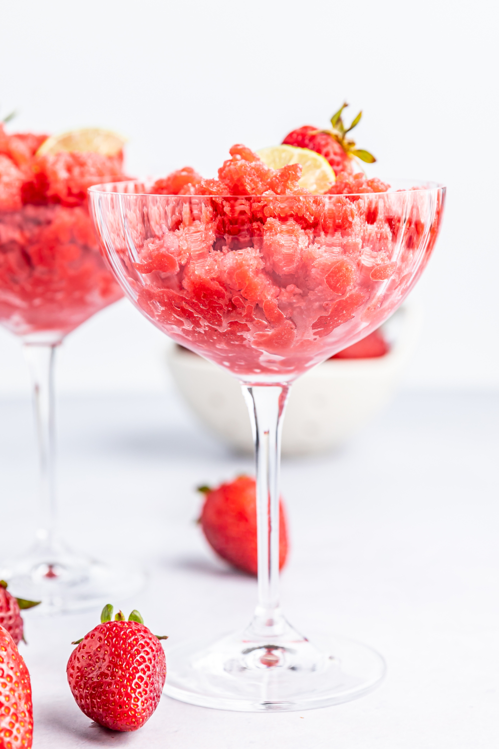 Strawberry granita in a glass with strawberries on the table. 