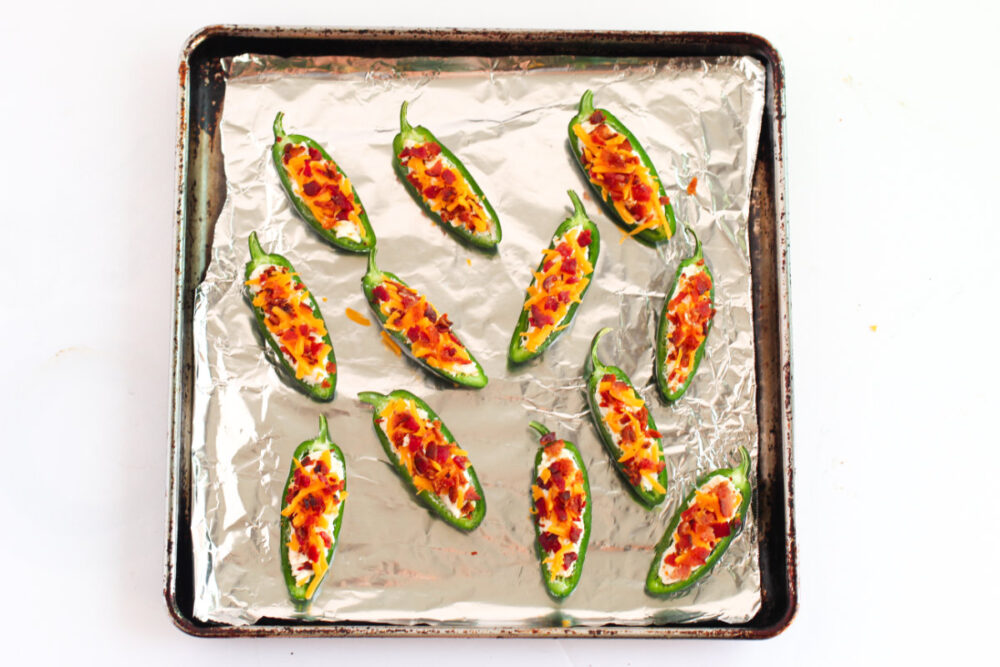 Jalepeno poppers on a baking sheet with foil. 