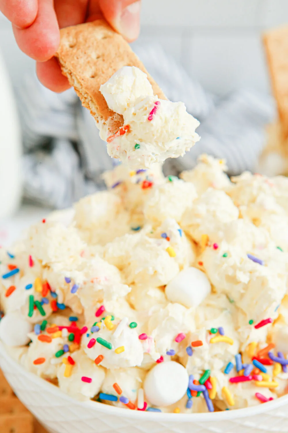 Dipping a graham cracker into birthday fluff. 