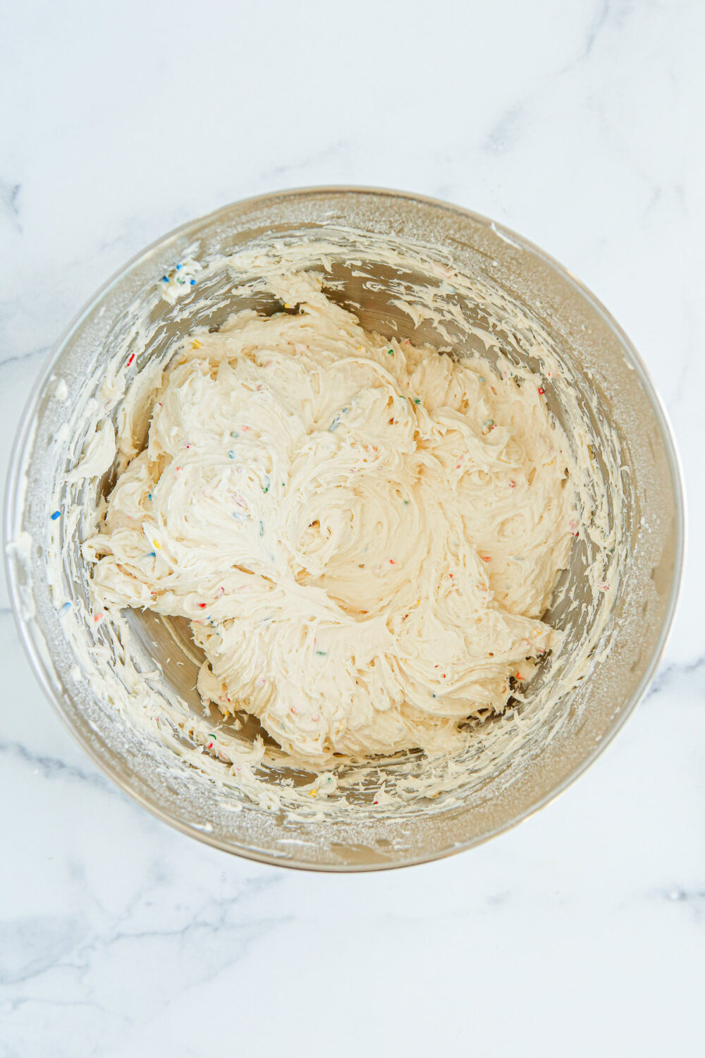 Cream cheese ball coming together in a mixing bowl. 