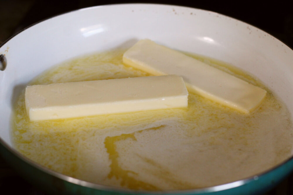 Sticks of butter melting in a skillet. 