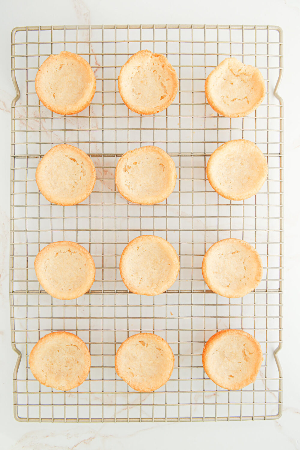 Sugar cookie mini crusts on a cooling rack. 