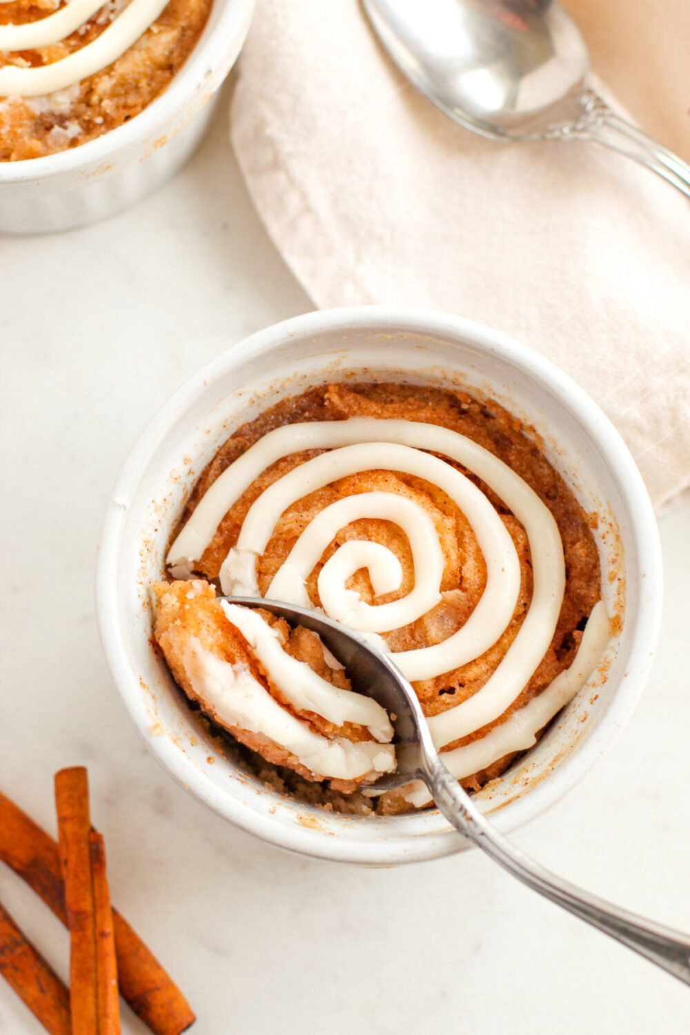 A spoon in a cinnamon roll cake.