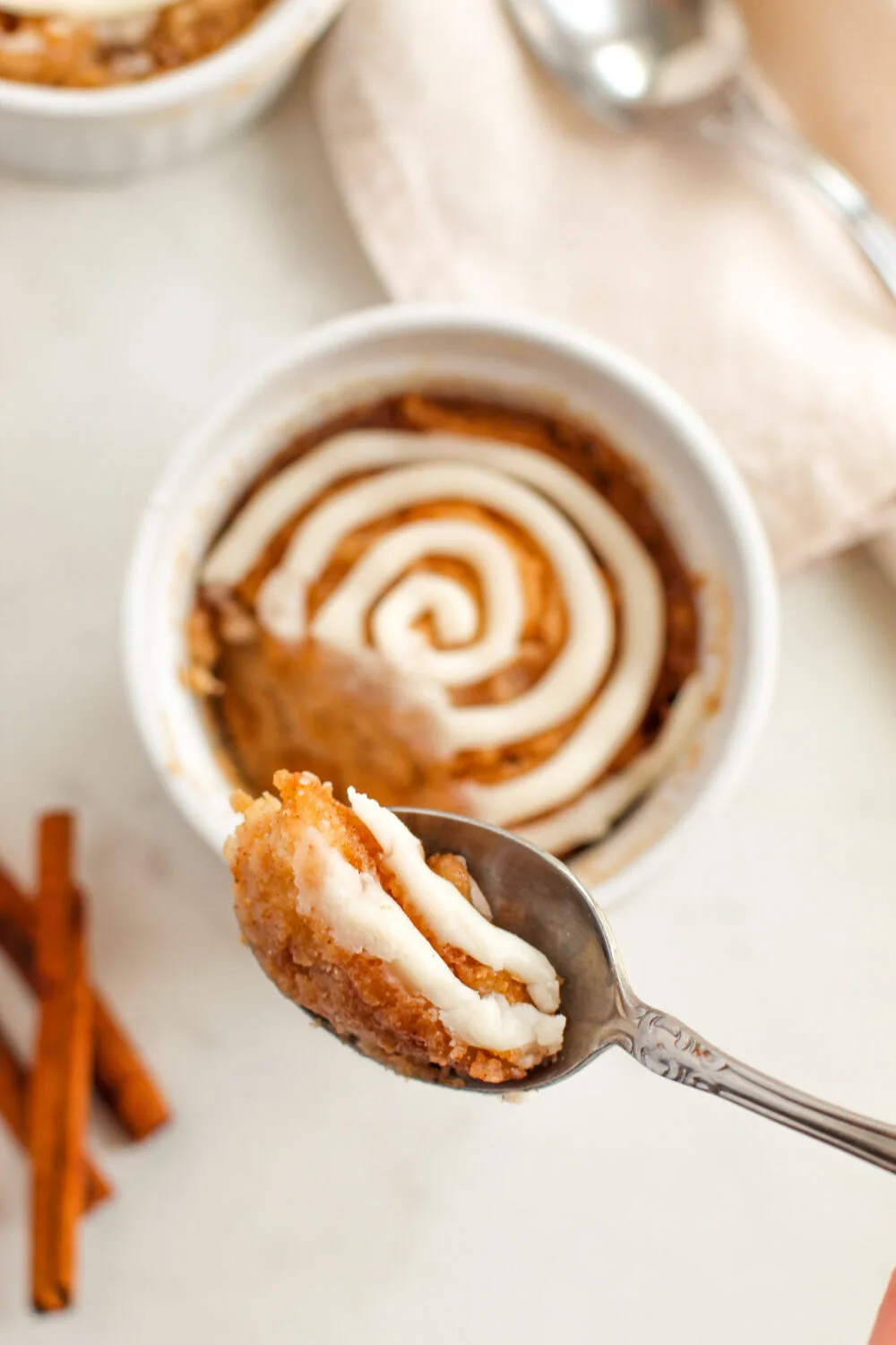 Spoonful of cinnamon cake with icing.