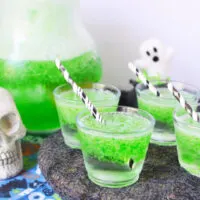 Cups of green jello smile Halloween drink.