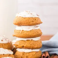 Stacked pumpkin cookies with icing.