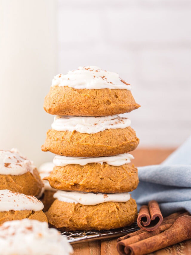 Stacked pumpkin cookies with icing.