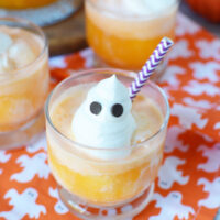 A whipped cream ghost on top of orange punch with ice cream.