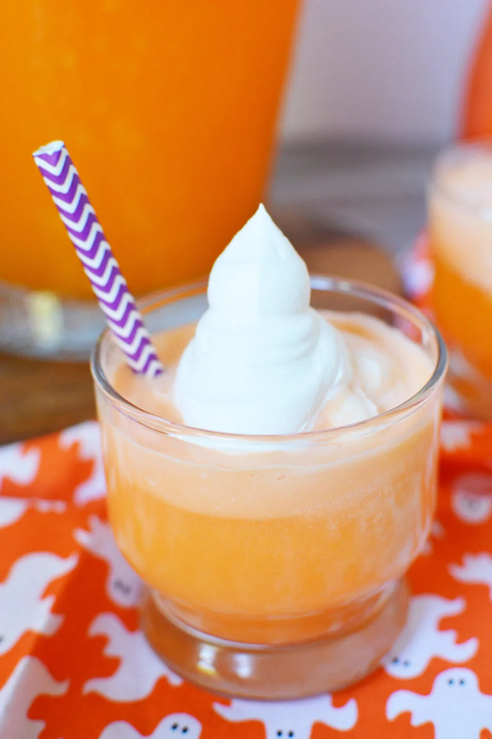 Whipped cream that looks like a ghost on top of orange ice cream punch. 