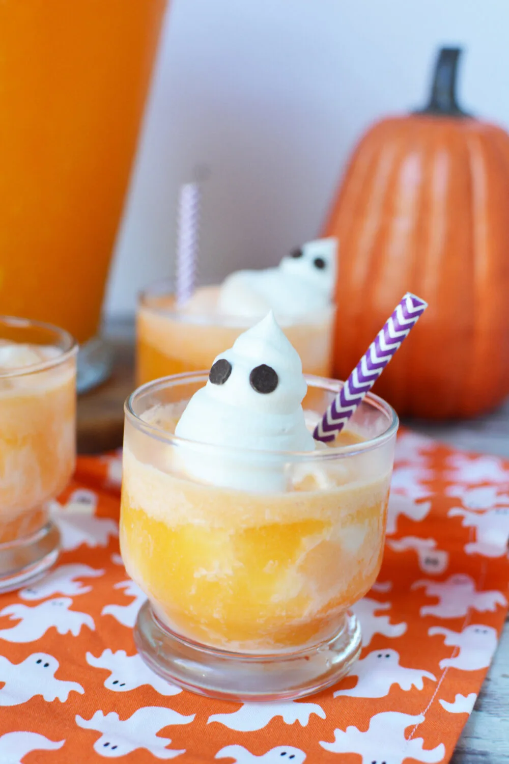 Orange punch with ice cream and whipped cream ghosts with chocolate chip eyes. 
