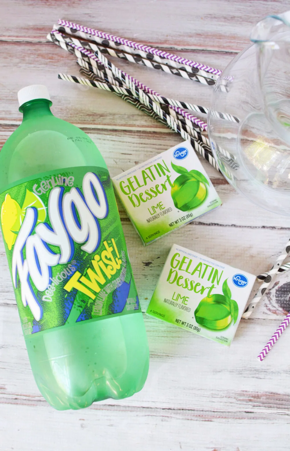 Faygo lemon lime drink, boxes of lime Jello and straws on a table. 