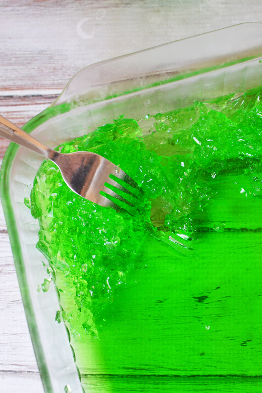 Using a fork to shred green jello. 
