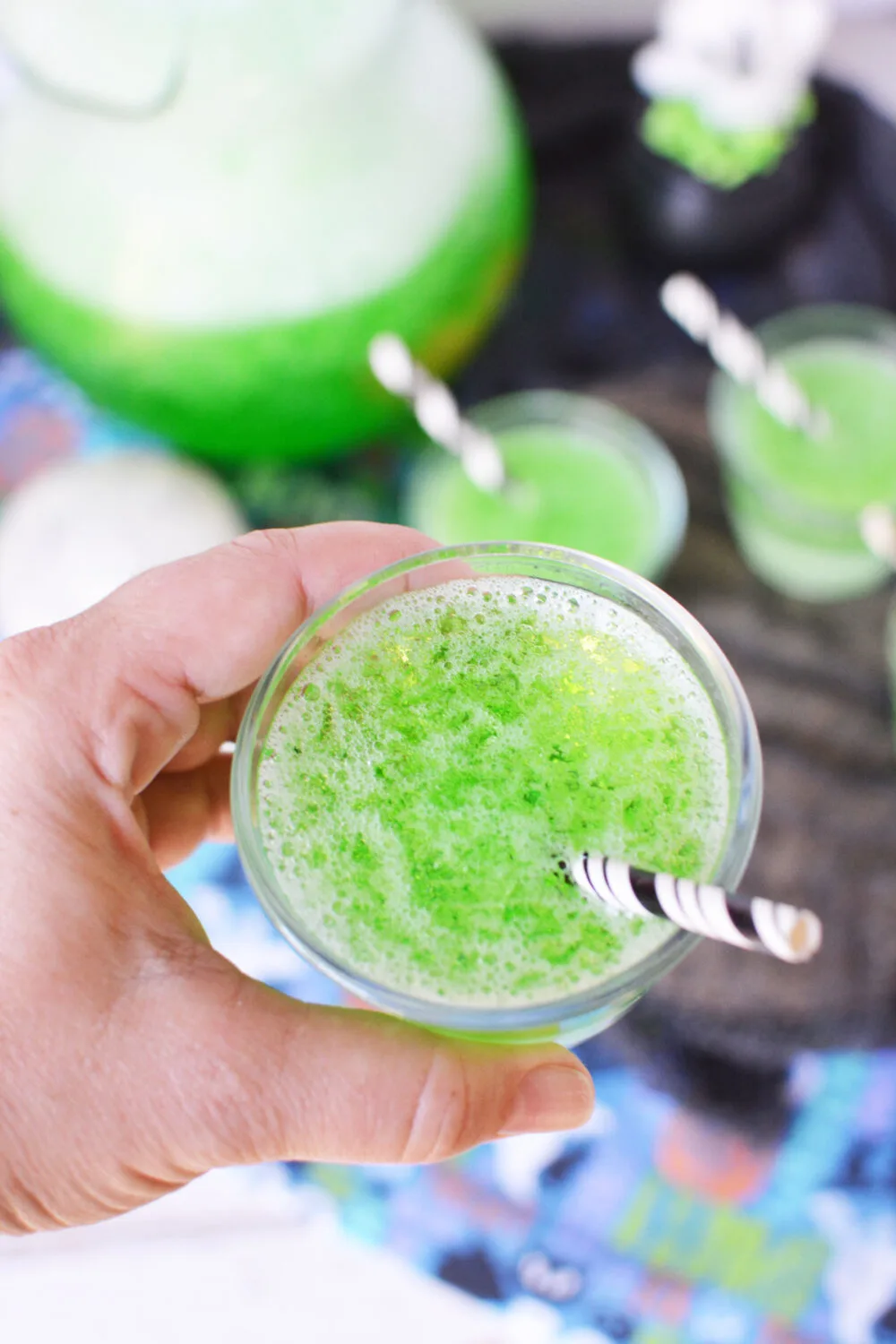 Holding a cup of green jello Halloween punch. 