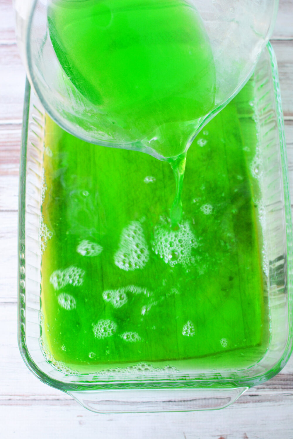 Pouring green jello into a 9x13 pan.