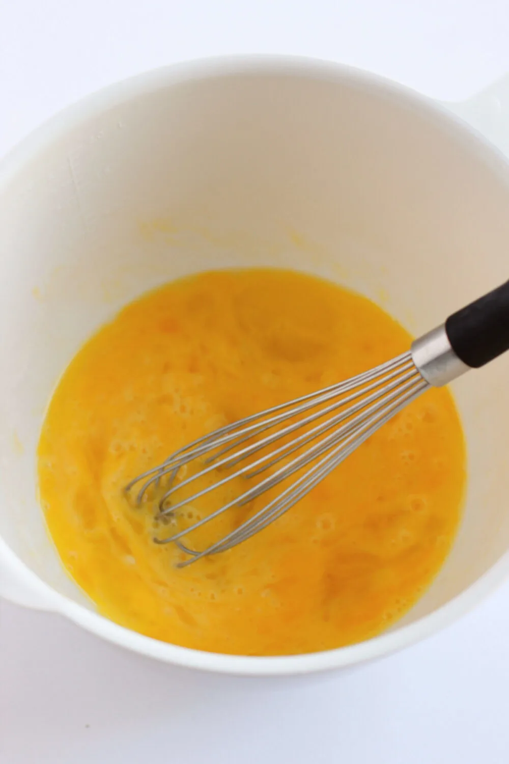Eggs in a bowl with a whisk. 