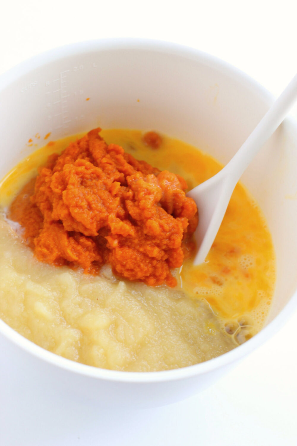 Pumpkin puree and eggs in a mixing bowl. 