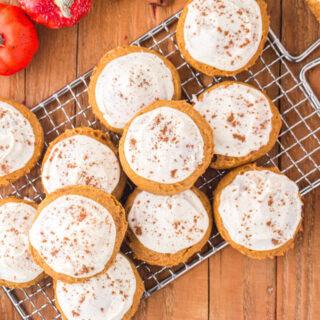 Iced pumpkin cookies on a wire rack.