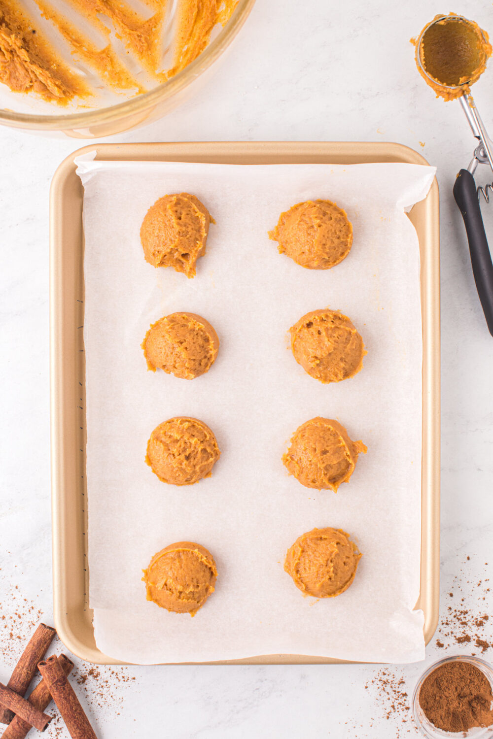 Pumpkin sugar cookie dough on a baking pan.