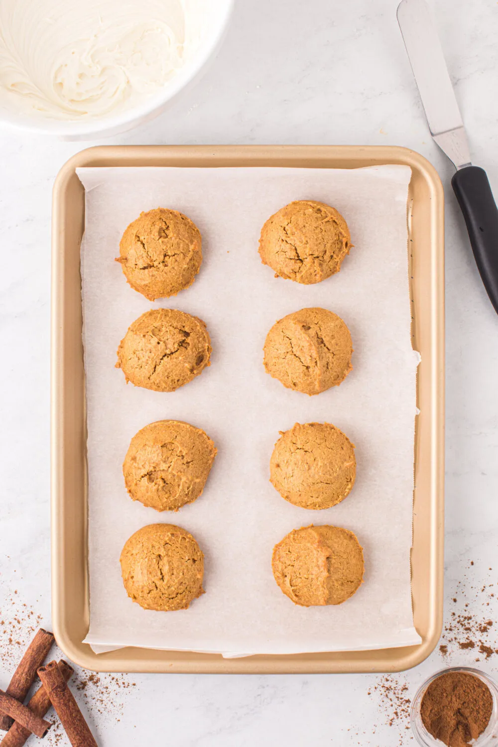 Baked pumpkin cookies on a baking sheet.