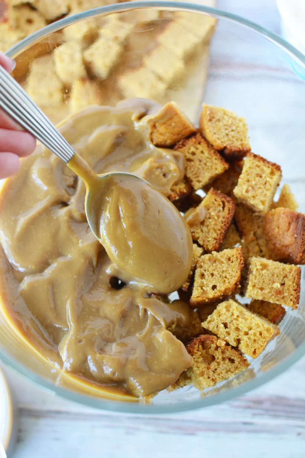 Coffee pudding on top of bread in a trifle dish. 