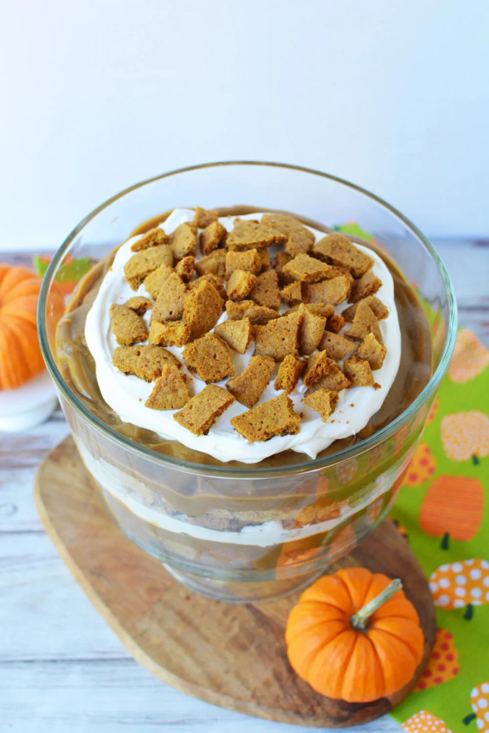 Pumpkin spice trifle in a bowl next to pumpkins.