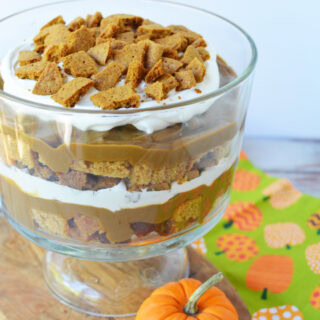 Layers of pumpkin, bread, whipped topping, and cookies in a trifle dessert.