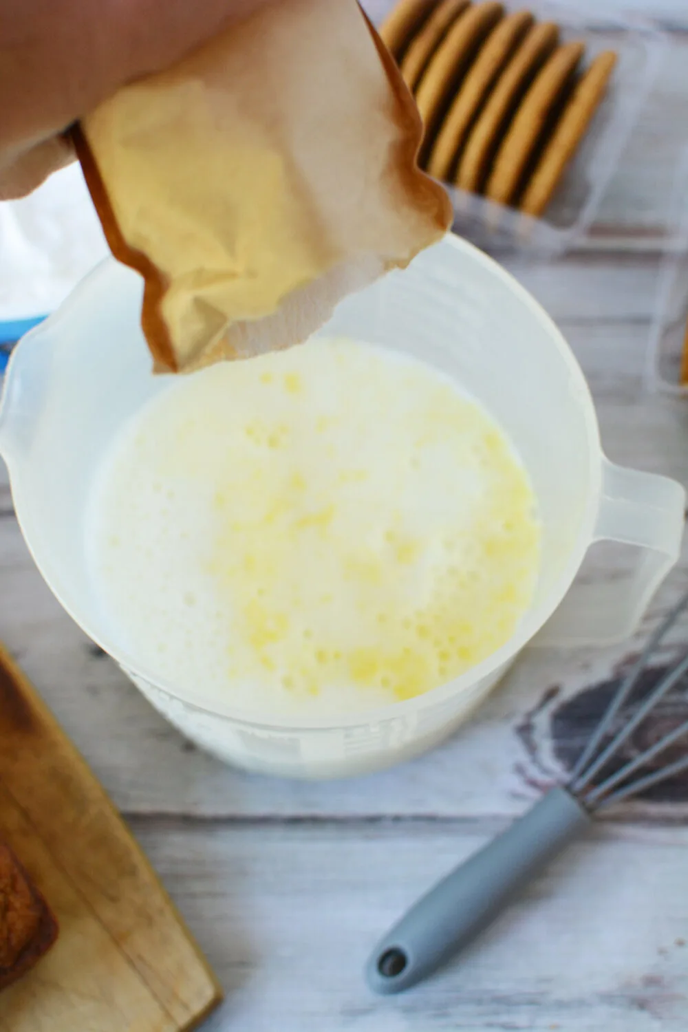 Adding instant pudding mix to milk. 