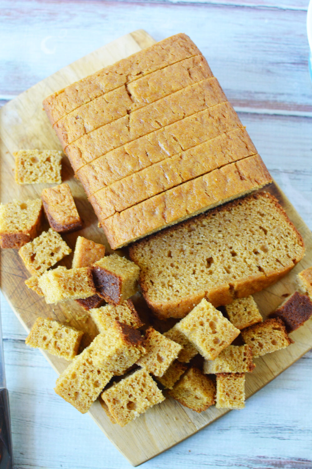 Pumpkin bread sliced and cut into cubes on a board. 