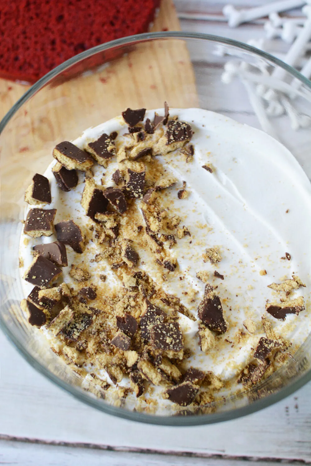 Crushed cookies on top of whipped topping in a bowl. 