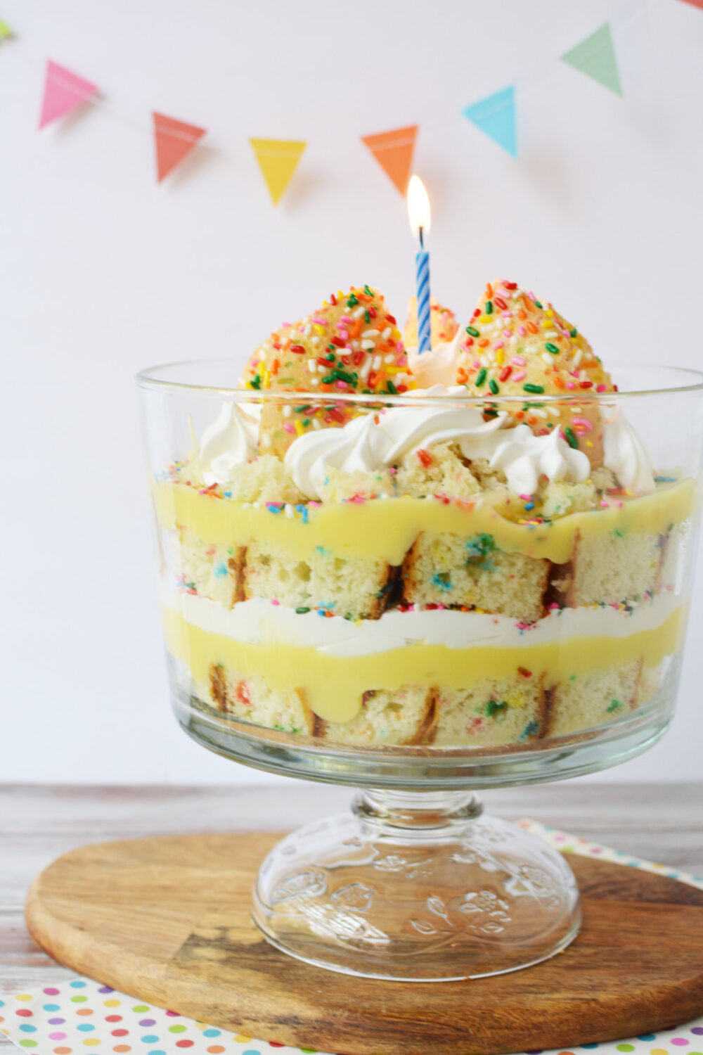 Trifle bowl full of funfetti cake, whipped cream, and cookies. 