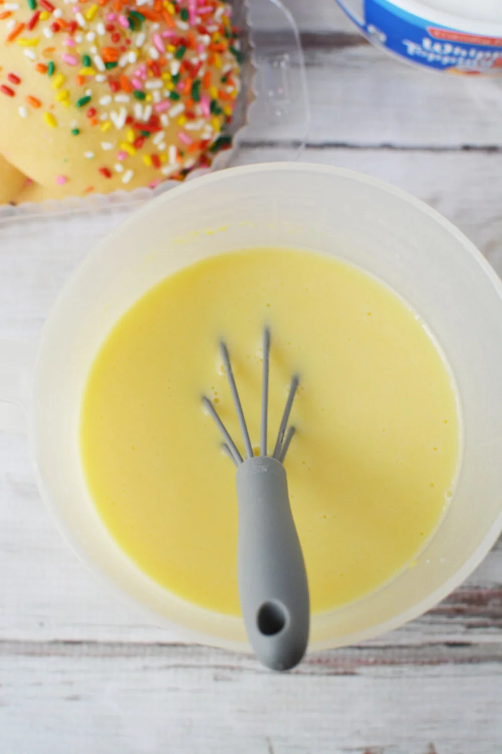Vanilla pudding in a bowl with a whisk. 
