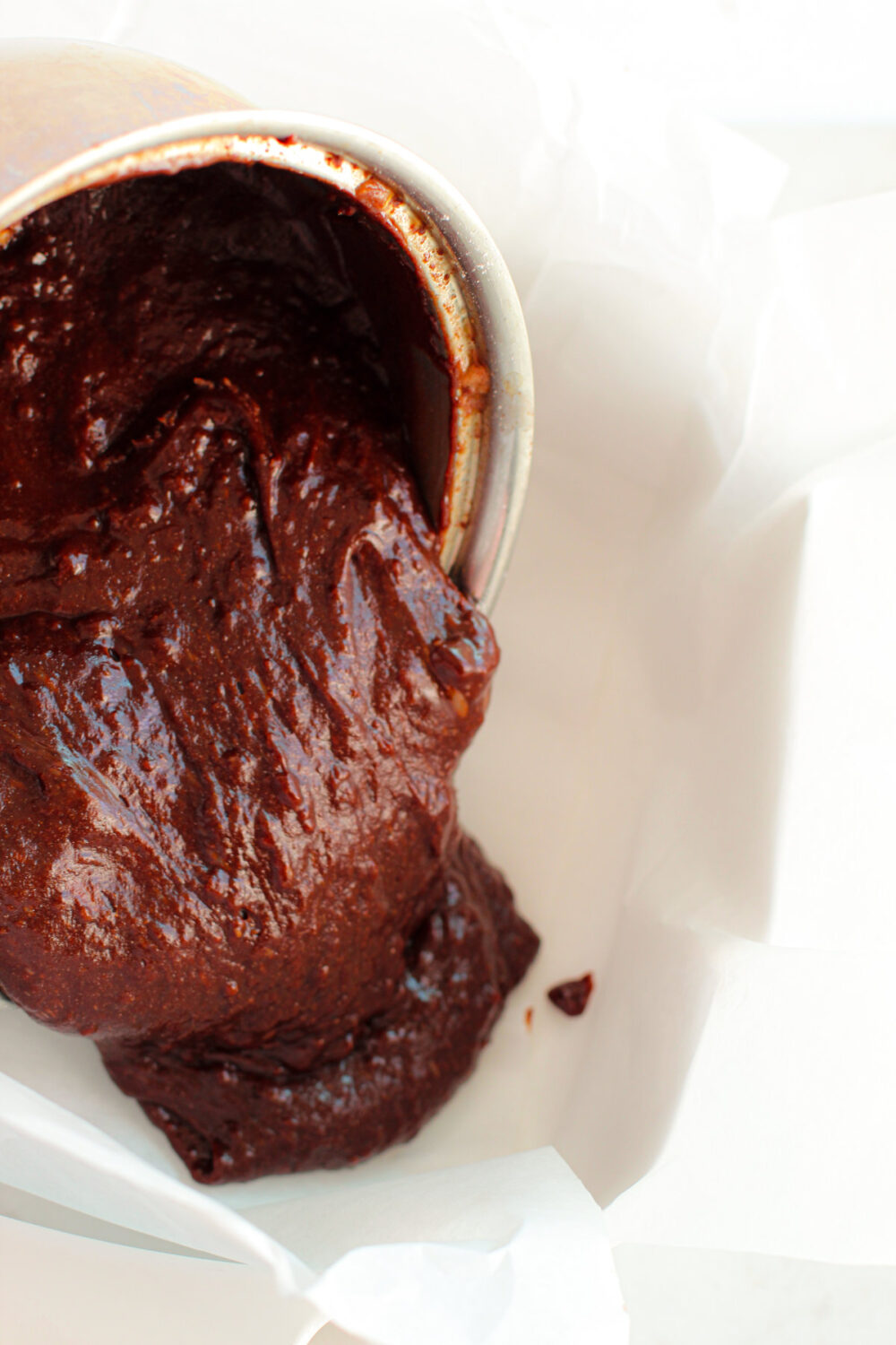 Pouring brownie batter into a pan.