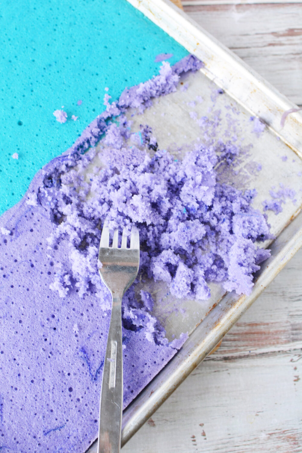 Using a fork to break up purple cake. 