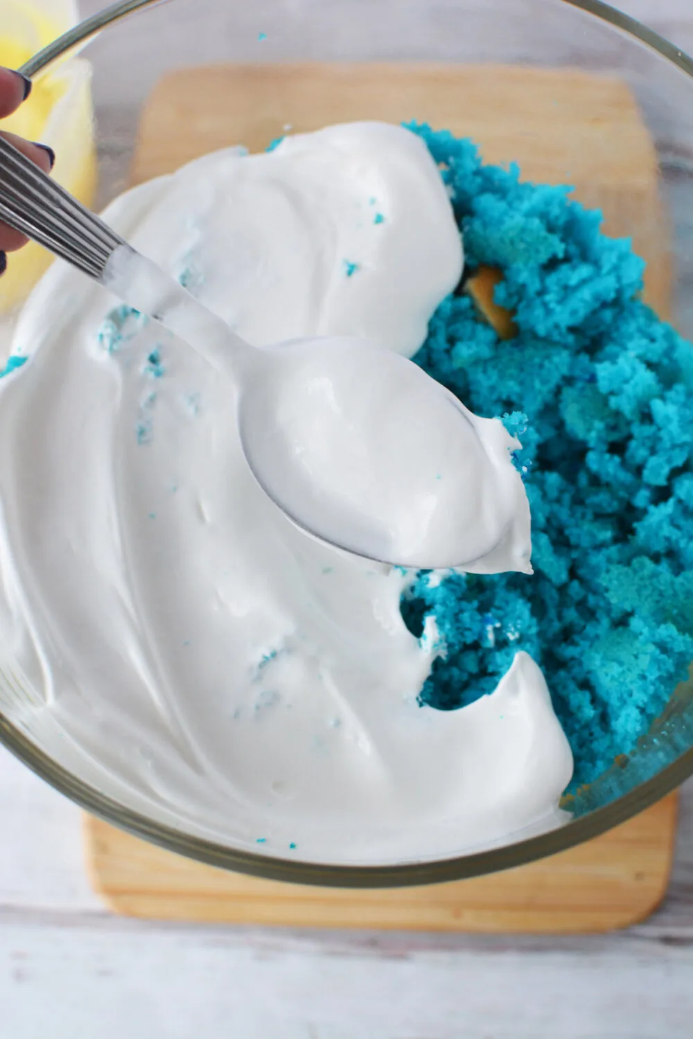Blue cake topped with whipped cream in a bowl. 
