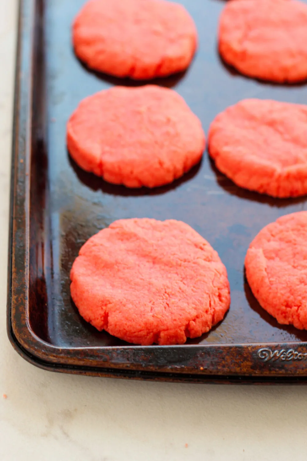 Strawberry cookie dough on a baking pan.