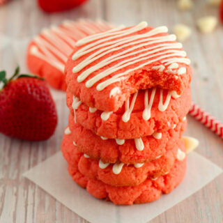 Strawberry cookies stacked with a bite taken out of the top one.