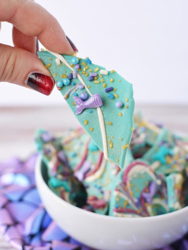 Holding a piece of mermaid bark with the bowl in the bacground.