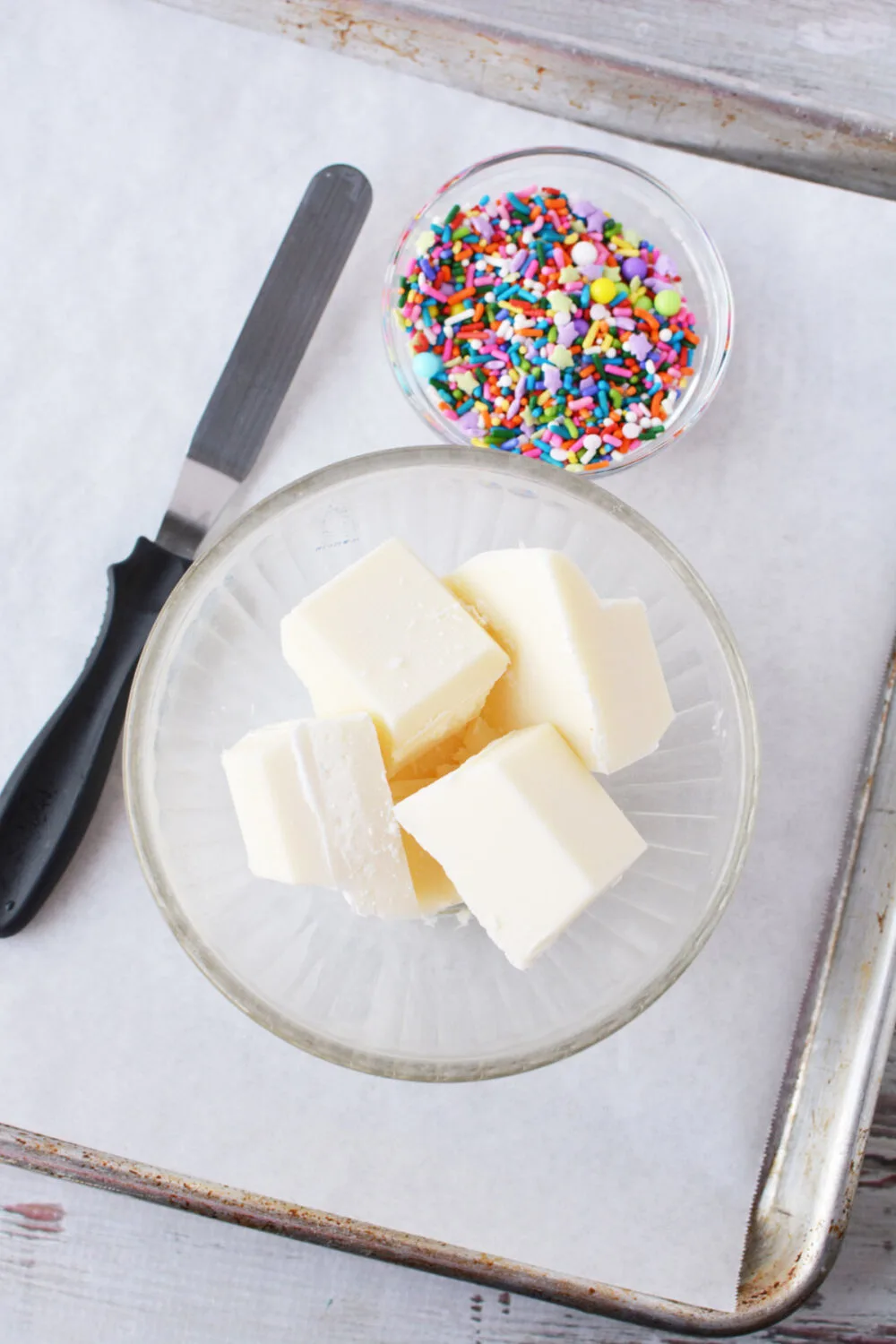 Almond bark and rainbow sprinkles in bowls. 