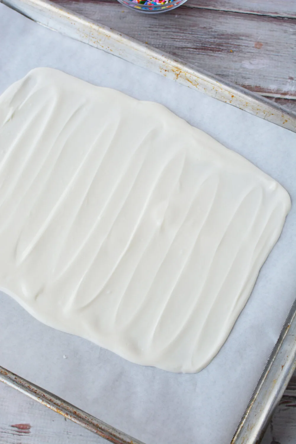 Almond bark smoothed out on a baking sheet. 