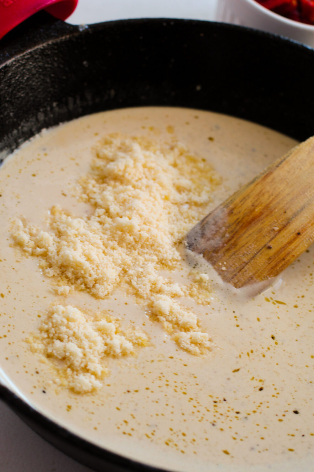 Parmesan cheese in a skillet with heavy cream mixture. 