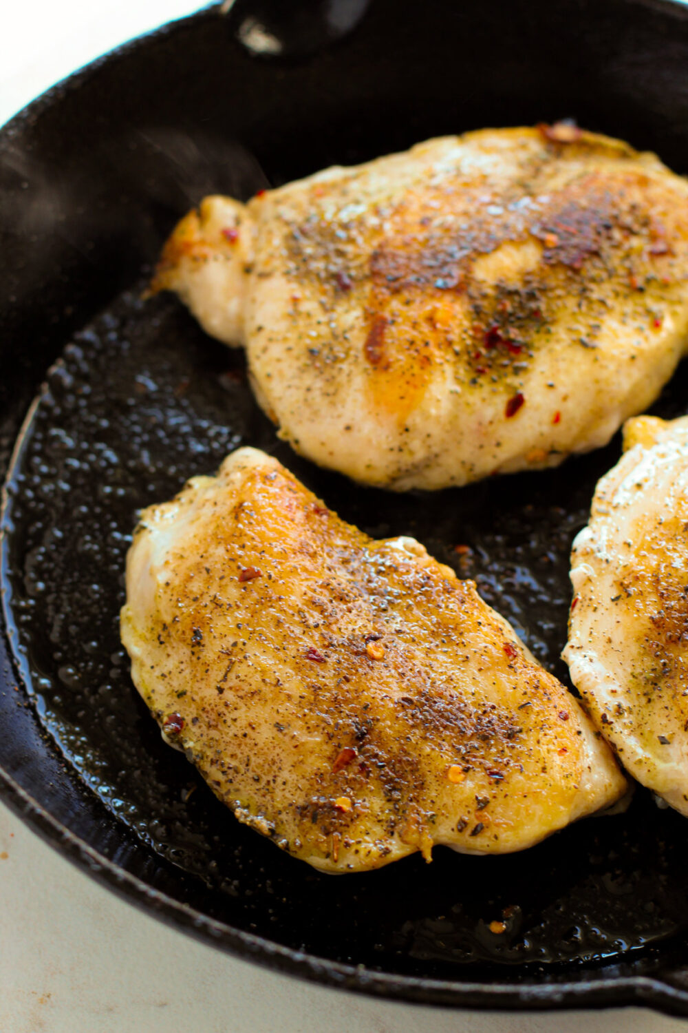Chicken breasts in a skillet.