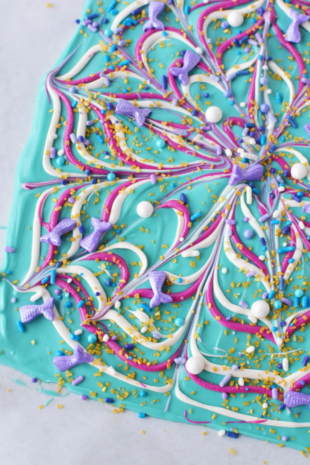 Swirled and sparkly mermaid bark candy on a sheet. 