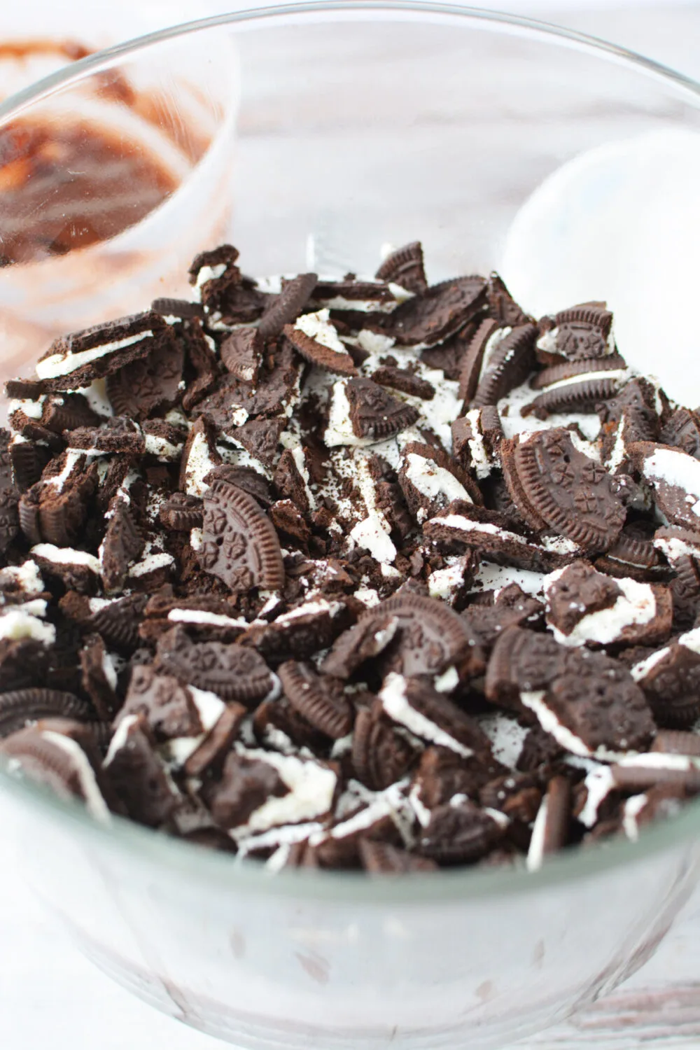 Chunks of chocolate sandwich cookies in a trifle bowl.