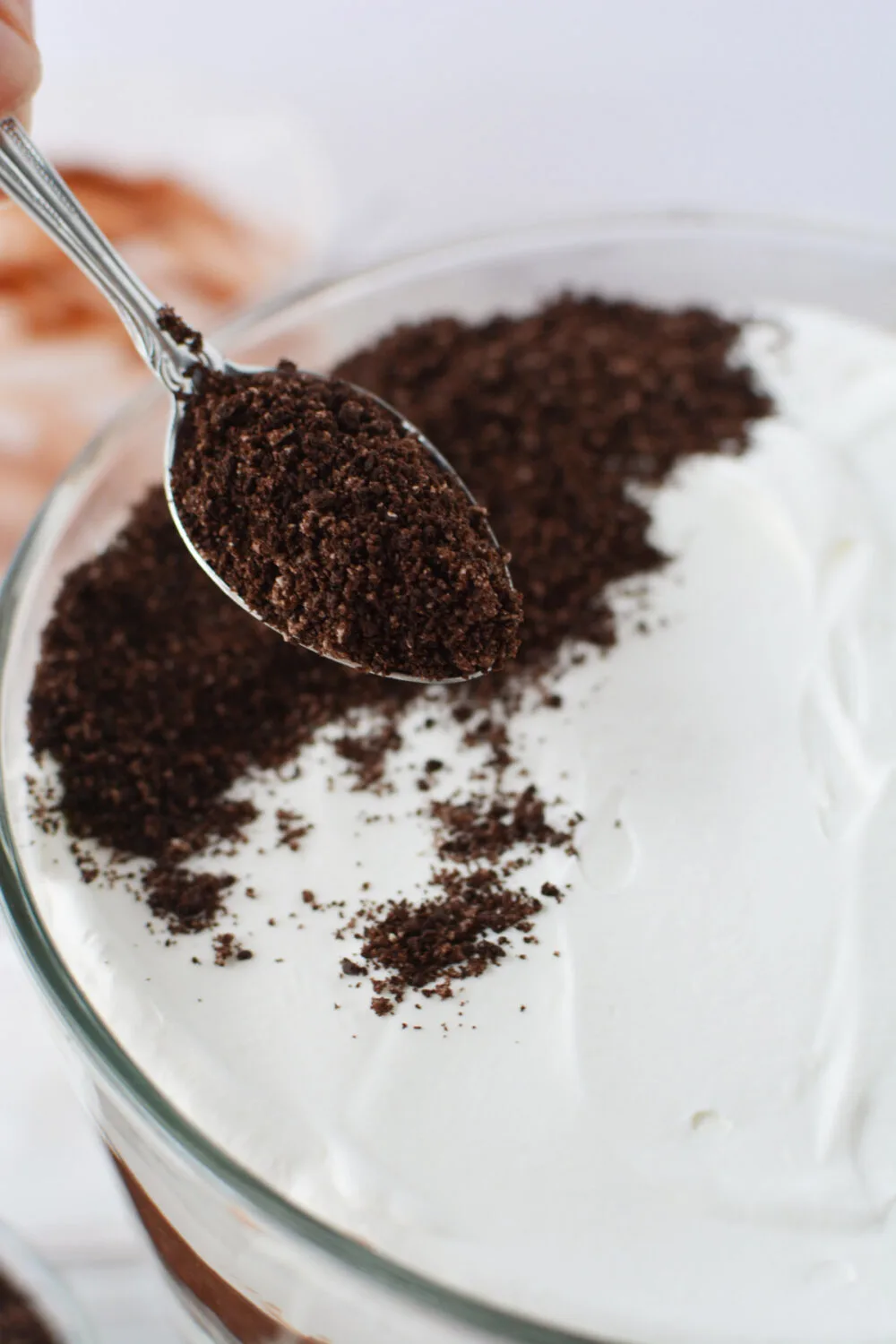 Finely crushed chocolate cookies on top of whipped cream. 